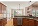 Modern kitchen with stainless dishwasher, wood cabinets, granite countertops, and bright windows at 10012 San Remo Pl, Wake Forest, NC 27587