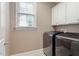 Bright laundry room with modern washer and dryer and storage cabinets at 10012 San Remo Pl, Wake Forest, NC 27587