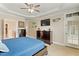 This main bedroom features a ceiling fan, television, and access to the backyard at 10012 San Remo Pl, Wake Forest, NC 27587