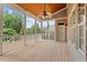 Screened-in porch with wood flooring, white railing, ceiling fan, and wooded views at 10012 San Remo Pl, Wake Forest, NC 27587