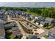 Aerial view of neighborhood featuring playground and community garden, nestled among colorful homes and lush greenery at 1008 Whistler St, Durham, NC 27713