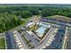 Aerial view of community pool, clubhouse, playground, and townhomes surrounded by lush green spaces and parking at 1008 Whistler St, Durham, NC 27713