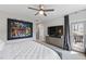 A spacious bedroom features a ceiling fan, and a TV, with a sliding glass door to a balcony at 1008 Whistler St, Durham, NC 27713