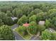Aerial view of a charming home with a red roof, surrounded by mature trees and beautiful landscaping at 101 Joel Ct, Cary, NC 27513