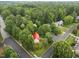 Aerial view shows a house with a red roof surrounded by a lush, green neighborhood at 101 Joel Ct, Cary, NC 27513