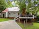 Wide backyard view of the house with a metal roof and shaded deck at 101 Joel Ct, Cary, NC 27513