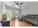 Cozy bedroom with hardwood floors, large windows, a ceiling fan, and stylish furnishings at 101 Joel Ct, Cary, NC 27513