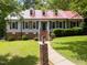 Charming home with red metal roof, black shutters, manicured lawn, and inviting walkway at 101 Joel Ct, Cary, NC 27513