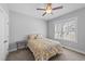 Bedroom with yellow bedding, ceiling fan, carpet, and a sun-filled window at 1013 Sagamore Dr, Louisburg, NC 27549