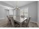 Formal dining room featuring a modern chandelier, a large window, and seating for six, ideal for entertaining guests at 1013 Sagamore Dr, Louisburg, NC 27549