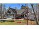 Charming gray home boasts a manicured lawn, an attached two-car garage, and a quaint front porch at 1013 Sagamore Dr, Louisburg, NC 27549