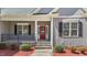 Inviting front entrance with a red door, stone steps, and manicured landscaping at 1013 Sagamore Dr, Louisburg, NC 27549