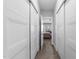 Hallway with multiple closet doors leading to a bedroom with a ceiling fan and natural light at 1013 Sagamore Dr, Louisburg, NC 27549