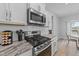 Modern kitchen showcases stainless steel appliances, granite countertops, and white subway tile backsplash at 1013 Sagamore Dr, Louisburg, NC 27549