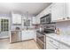 Well-lit kitchen featuring granite countertops, stainless steel appliances, and ample cabinet space at 107 E Seve Ct, Morrisville, NC 27560