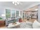 Cozy living room with large windows, comfortable seating, and open floor plan to the kitchen at 107 E Seve Ct, Morrisville, NC 27560
