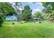 Well-maintained backyard featuring lush lawn, mature trees, a greenhouse and space for recreation at 108 High St, Carrboro, NC 27510