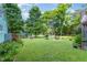 Expansive backyard with mature trees, firepit, playground, and outdoor dining area at 108 High St, Carrboro, NC 27510
