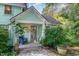 Close-up of charming front porch with stone walkway, potted plants, and serene seating area at 108 High St, Carrboro, NC 27510