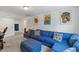 Bonus room with a large blue sectional sofa and ample space for relaxation at 120 Misty Grove Trail Trl, Franklinton, NC 27525