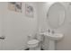 Clean powder room featuring a pedestal sink, toilet, and decorative wall art at 120 Misty Grove Trail Trl, Franklinton, NC 27525