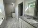Primary bathroom featuring marble floors, dual vanities, and a separate soaking tub at 129 Hot Springs Way, Benson, NC 27504