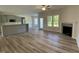 Open-concept living area with a modern fireplace, wood floors, and lots of natural light at 129 Hot Springs Way, Benson, NC 27504