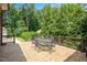 Tiled backyard deck with table, chairs, and a wooded view at 1313 Duplin Rd, Raleigh, NC 27607