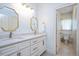 Bathroom with double sinks, marble counters, decorative mirrors, and a separate toilet room at 1313 Duplin Rd, Raleigh, NC 27607