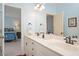 Bright bathroom with double vanity, white cabinets, and updated fixtures; Primary bedroom is connected at 1313 Duplin Rd, Raleigh, NC 27607