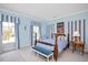 Bedroom featuring blue and white striped valances, light blue paint and carpet, and a queen bed at 1313 Duplin Rd, Raleigh, NC 27607