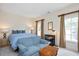 Bedroom featuring neutral walls, a blue sofa, queen size bed, and two windows at 1313 Duplin Rd, Raleigh, NC 27607