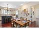 Traditional dining area with hardwood floors, a decorative chandelier, and bright natural light from the nearby window at 1313 Duplin Rd, Raleigh, NC 27607