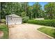 Detached two-car garage with basketball hoop on a concrete driveway lined with green grass and hedge at 1313 Duplin Rd, Raleigh, NC 27607