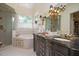 Luxurious main bathroom with a glass-enclosed shower, soaking tub, and double vanity with granite countertop at 1313 Duplin Rd, Raleigh, NC 27607