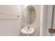 Compact powder room featuring a pedestal sink, oval mirror, towel rack, and light walls at 1365 Scholar Dr, Durham, NC 27703