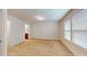 Spacious bedroom has neutral colored walls and carpet, and it opens to a bathroom with a wood cabinet at 1365 Scholar Dr, Durham, NC 27703
