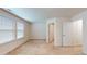 Bright carpeted bedroom features neutral walls, large windows with blinds and entryways to other rooms at 1365 Scholar Dr, Durham, NC 27703