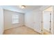 Bright bedroom features neutral carpet, a window with blinds and white trim, and white walls and doors at 1365 Scholar Dr, Durham, NC 27703