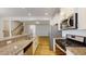 Open kitchen with granite countertops, stainless steel appliances, and a breakfast bar overlooking the staircase at 1365 Scholar Dr, Durham, NC 27703