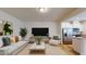 Bright living room featuring a comfortable sofa, stylish accent chair, and modern decor adjacent to the open kitchen at 1365 Scholar Dr, Durham, NC 27703