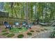 Serene backyard retreat with Adirondack chairs around a fire pit, a hammock, and lush landscaping for relaxation at 1426 Kildaire Farm Rd, Cary, NC 27511