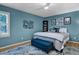 Comfortable bedroom featuring blue walls, ceiling fan, patterned rug, and ample natural light at 1426 Kildaire Farm Rd, Cary, NC 27511