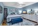 Comfortable bedroom with blue walls, a patterned rug, a ceiling fan, and decorative furniture at 1426 Kildaire Farm Rd, Cary, NC 27511