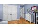 Light blue bedroom with hardwood flooring, large closet, and modern workspace at 1426 Kildaire Farm Rd, Cary, NC 27511