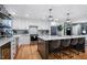Modern kitchen with an island, white cabinets, stainless steel appliances, and hardwood floors at 1426 Kildaire Farm Rd, Cary, NC 27511