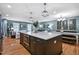 Open concept kitchen with hardwood flooring, large island that extends into a dining table, and living room at 1426 Kildaire Farm Rd, Cary, NC 27511