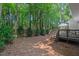 Wooded backyard featuring a deck, surrounded by mature trees at 1701 Berwickshire Cir, Raleigh, NC 27615