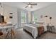 A cozy bedroom with a ceiling fan and a neat desk area with natural light from two windows at 1701 Berwickshire Cir, Raleigh, NC 27615