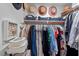 Organized closet with clothes hanging on a rod and a shelf with decorations and storage boxes at 1701 Berwickshire Cir, Raleigh, NC 27615